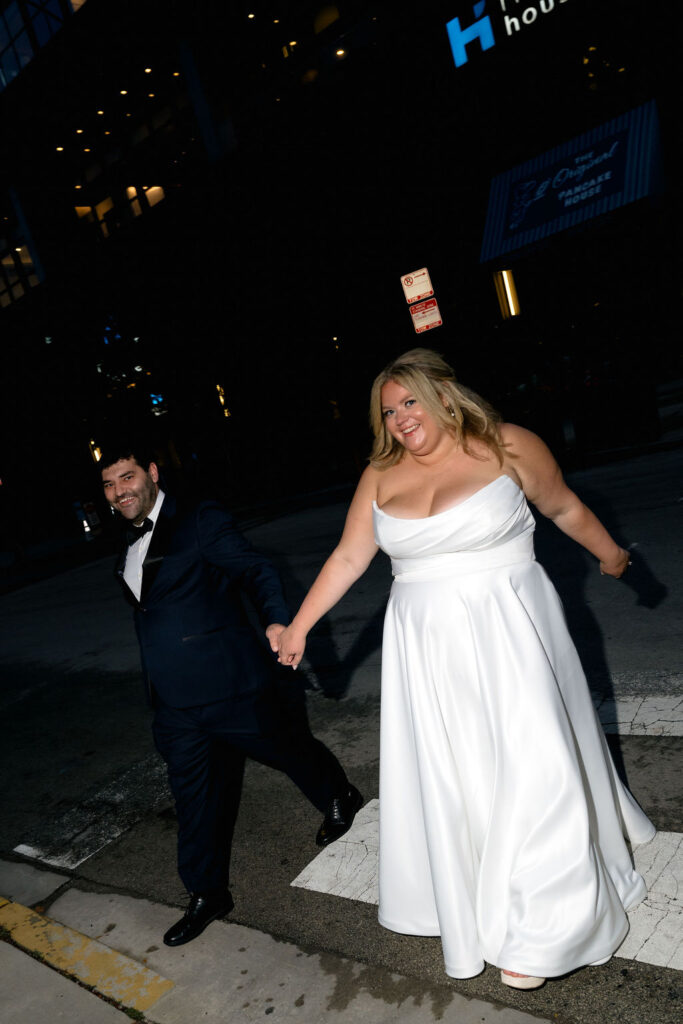 bride and groom wedding couples photos on chicago walking in street in front of hyatt hotel